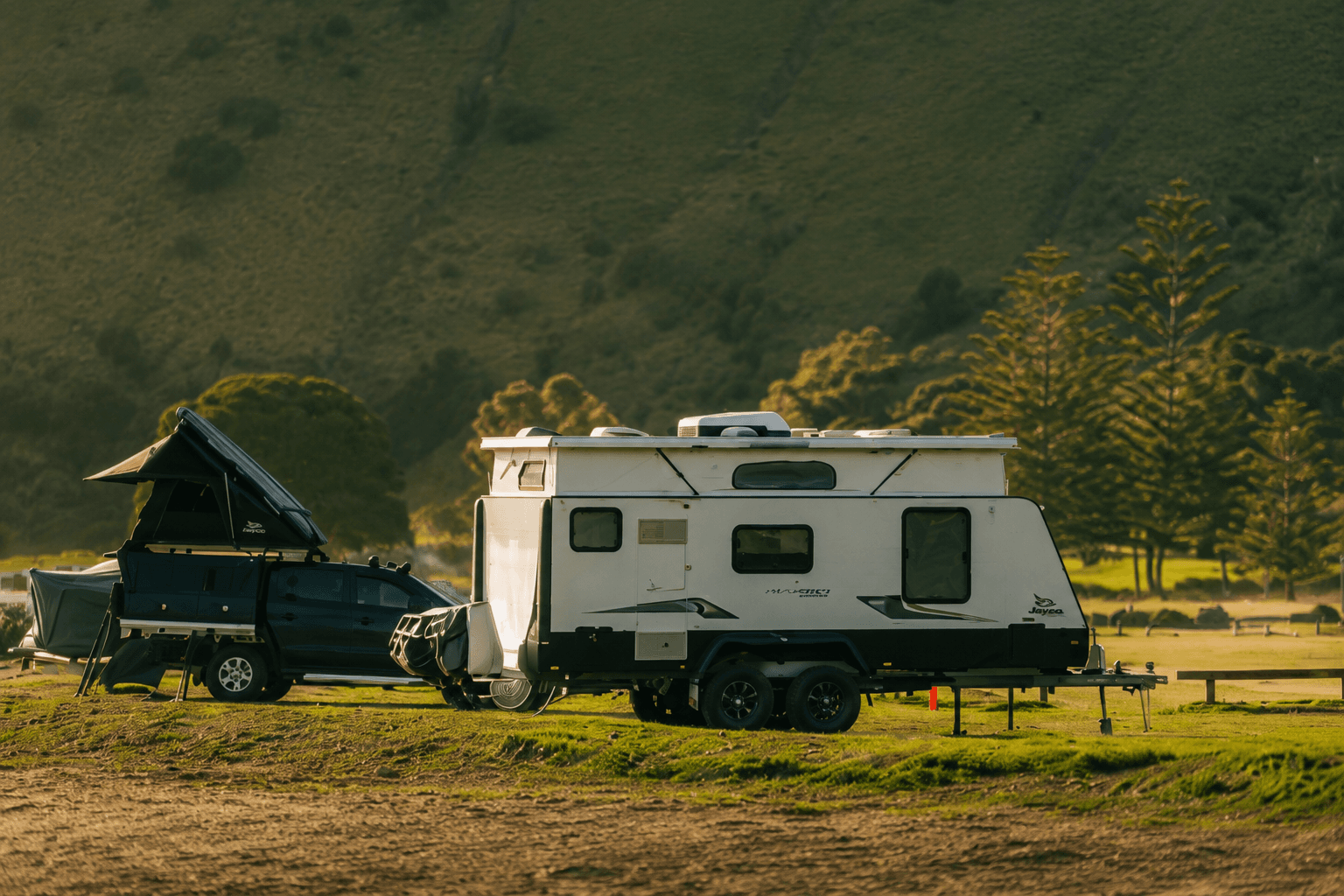 Caravan parked at a scenic mountain campsite at golden hour